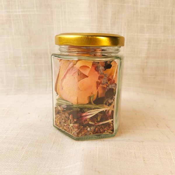 For your natural South Asian hair care routine, a glass jar with gold lid, and gulabi hair rinse blend inside. Shows flaxseed, rose, hibiscus, rosemary and lavender